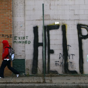 DETROIT - NOVEMBER 20: A pedestrian walks by graffiti on a downtown street November 20, 2008 in Detroit, Michigan. An estimated one in three Detroiters lives in poverty, making the city the poorest large city in America. The Big Three U.S. automakers, General Motors, Ford and Chrysler, are appearing this week in Washington to ask for federal funds to curb to decline of the American auto industry. Detroit, home to the big three, would be hardest hit if the government lets the auto makers fall into bankruptcy. (Photo by Spencer Platt/Getty Images)